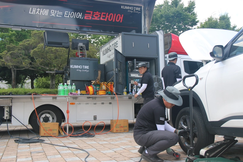 사진설명  ＝금호타이어 직원들이 광주광역시청 야외음악당에 마련된 '타이어 무상점검' 캠페인에서 방문객의 차량을 점검하고 있다