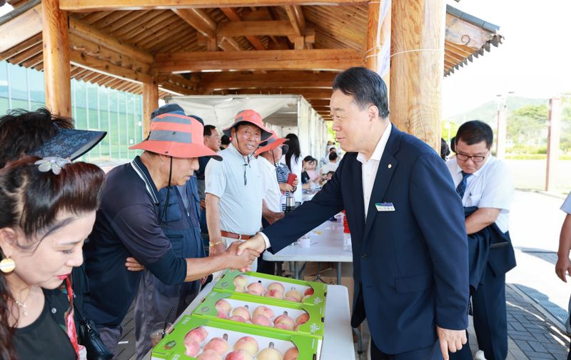 사진설명 = 제15회 화순 명품 복숭아 축제 판매장에서 구복규 화순군수가 농업인과 악수하는 모습