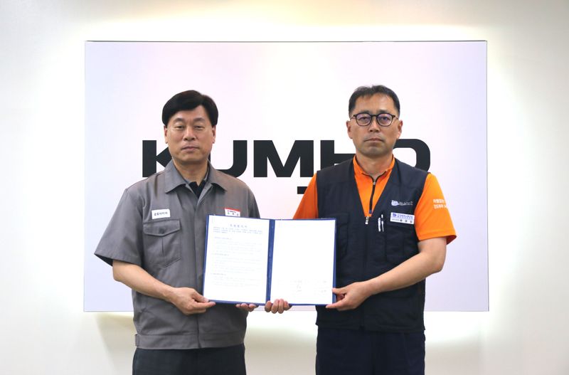 사진설명 = 김명선 금호타이어 생산기술총괄 부사장(사진 왼쪽)과 황용필 금호타이어지회 대표 지회장이 노사 특별합의문을 들고 사진을 찍고 있다.