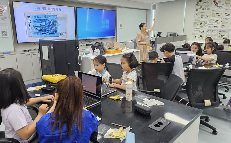 사진설명 = 창의융합교육원, 과학교육체험관 여름 특별프로그램 운영 - 디지털 현미경으로 지폐를 관찰하는 모습