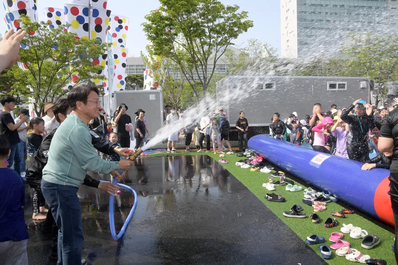 사진설명 = 강기정 광주광역시장이 지난해 5월25일 제59회 광주시민의 날을 맞아 시청 앞에 설치된 '워터월드'에서 시원한 물줄기를 뿌리자 어린이들이 환호하고 있다.