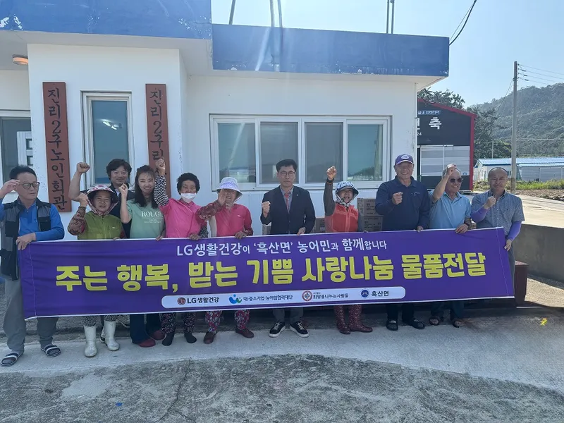 사진설명 =사)희망을나누는사람들 후원 물품과 흑산면 주민들이 함께 기념 촬영을 하고 있다.